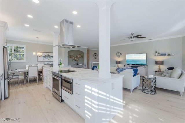 kitchen with decorative columns, island range hood, appliances with stainless steel finishes, light stone countertops, and crown molding