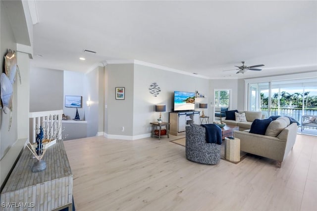 living area featuring visible vents, crown molding, baseboards, and wood finished floors