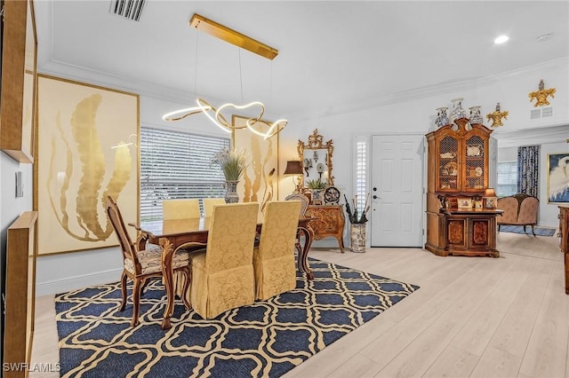 dining area featuring visible vents, crown molding, an inviting chandelier, and wood finished floors