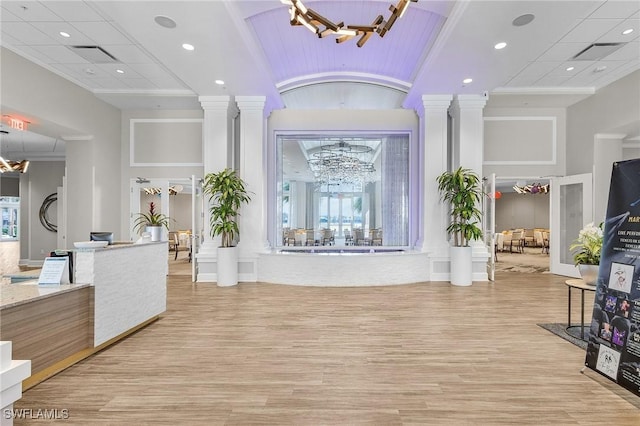 reception with visible vents, a notable chandelier, and ornate columns