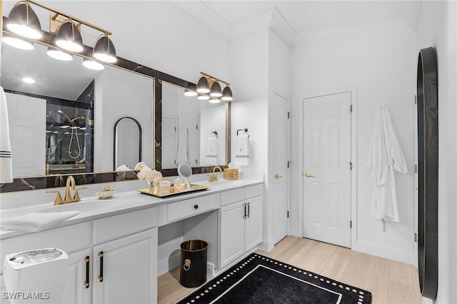 full bath featuring double vanity, ornamental molding, wood finished floors, and a sink