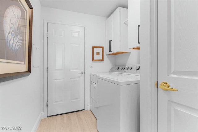 clothes washing area with washer and dryer, light wood-type flooring, cabinet space, and baseboards