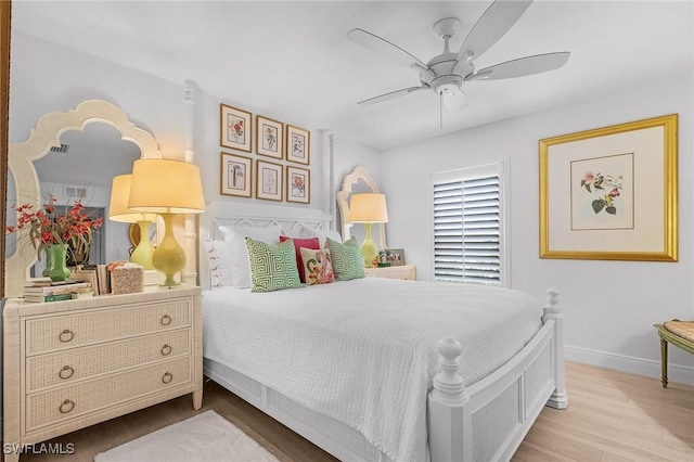 bedroom featuring wood finished floors, baseboards, and ceiling fan