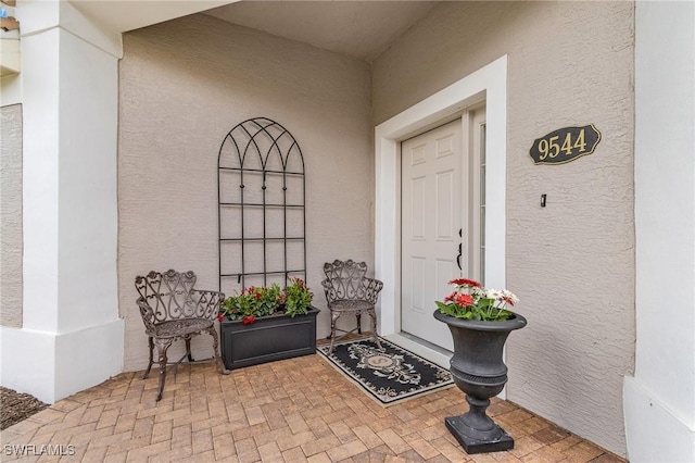 property entrance with stucco siding