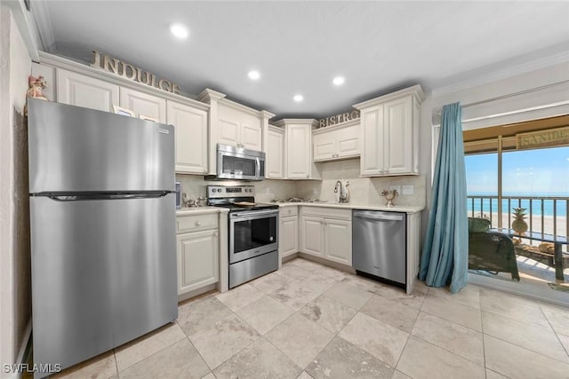 kitchen featuring stainless steel appliances, light countertops, a sink, and decorative backsplash