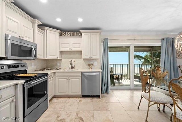 kitchen featuring crown molding, light countertops, backsplash, appliances with stainless steel finishes, and a sink