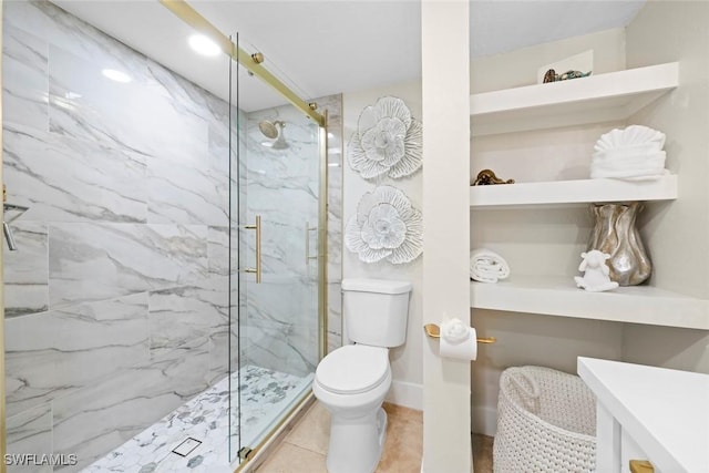 bathroom featuring toilet, a marble finish shower, and vanity