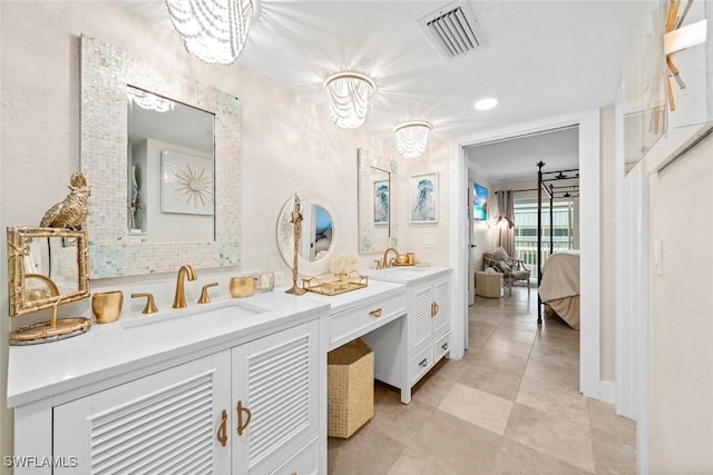 full bath with ensuite bathroom, double vanity, a sink, and visible vents