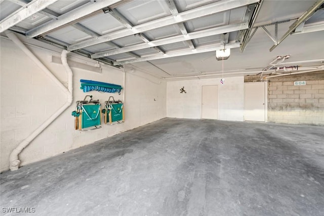 garage featuring a garage door opener and concrete block wall