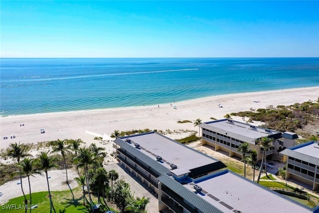 birds eye view of property with a water view and a beach view