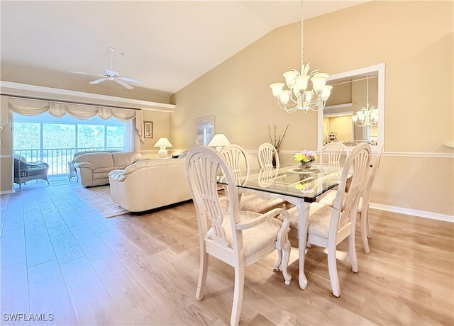 dining area with vaulted ceiling, light wood finished floors, ceiling fan with notable chandelier, and baseboards