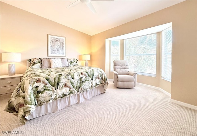 carpeted bedroom with lofted ceiling, a ceiling fan, and baseboards