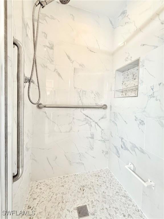 full bathroom with a marble finish shower