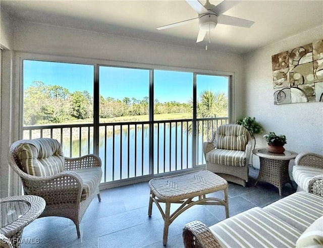 sunroom / solarium with a ceiling fan and a water view