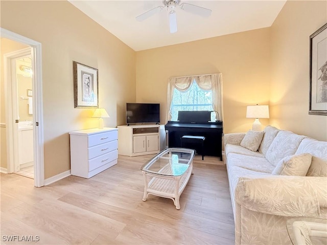 living room with baseboards, ceiling fan, and light wood finished floors