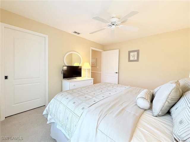 bedroom with light carpet, visible vents, and a ceiling fan