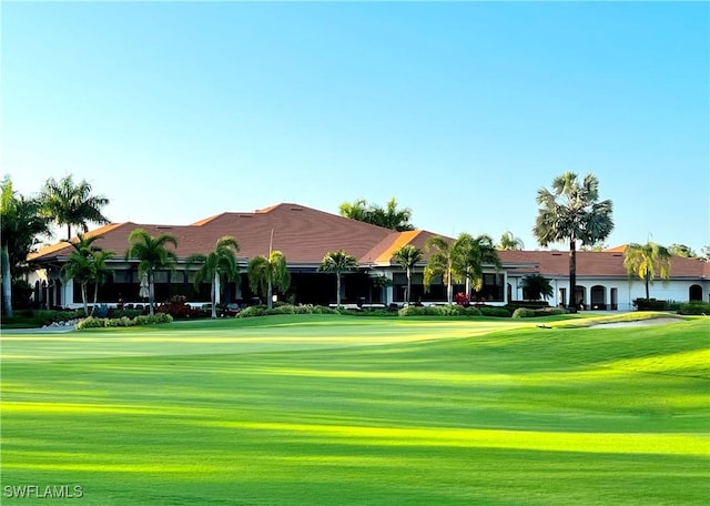 view of home's community with view of golf course and a yard