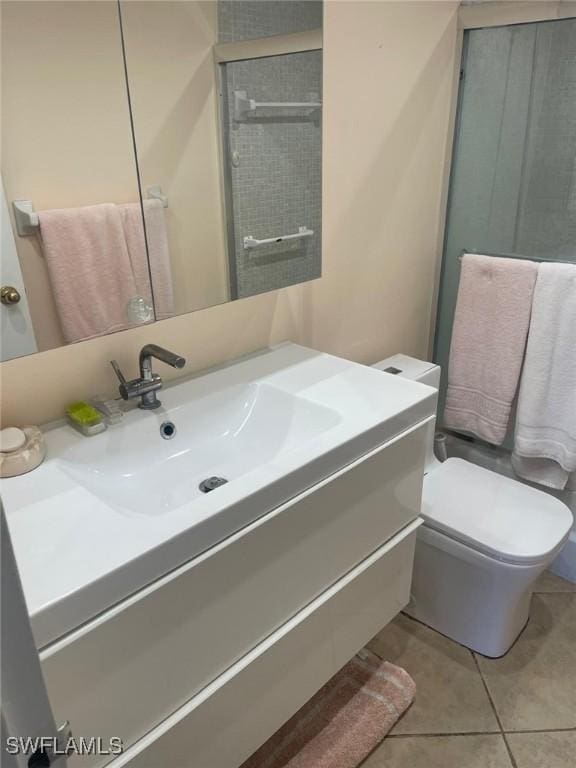 bathroom with toilet, tile patterned floors, and vanity