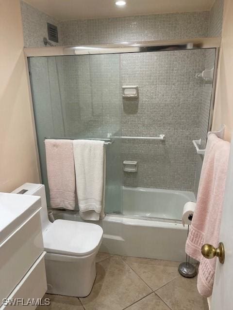 full bathroom featuring visible vents, toilet, tile patterned flooring, combined bath / shower with glass door, and vanity