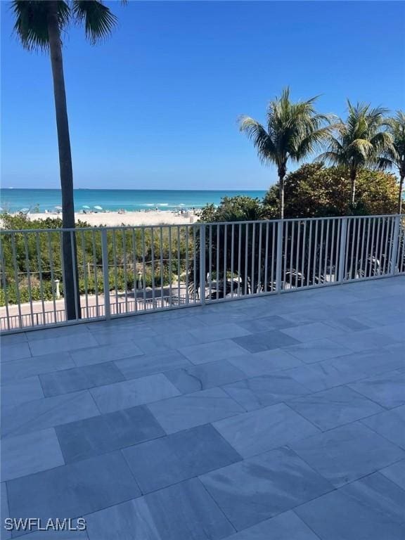 view of patio featuring a beach view and a water view