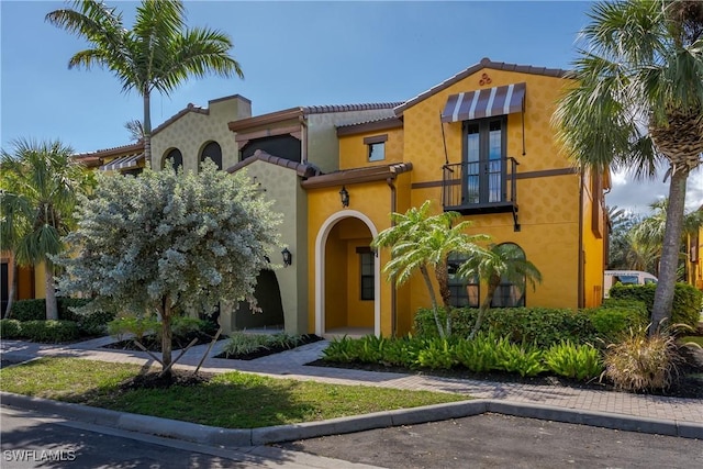 mediterranean / spanish home with stucco siding and a balcony