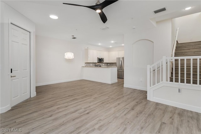 9072 Covina Dr N Unit 5505, Naples, FL 34113 - unfurnished living room featuring a ceiling fan, stairway, recessed lighting, light wood-type flooring, and baseboards
