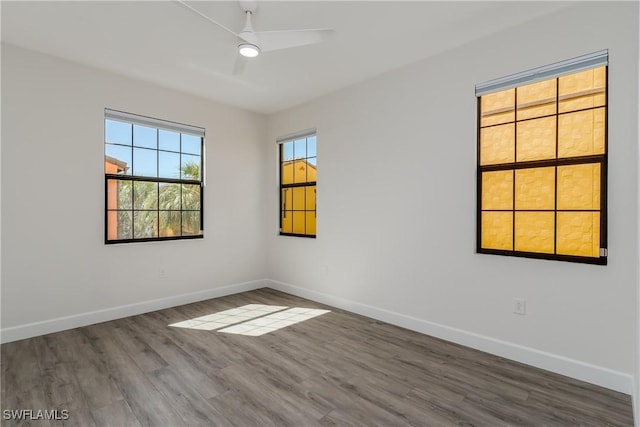 empty room with wood finished floors, baseboards, and ceiling fan