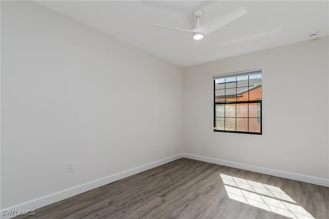 unfurnished room with a ceiling fan, wood finished floors, and baseboards