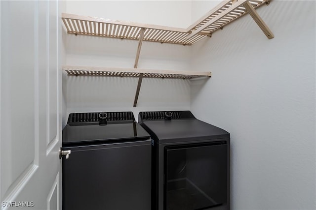 clothes washing area featuring separate washer and dryer and laundry area