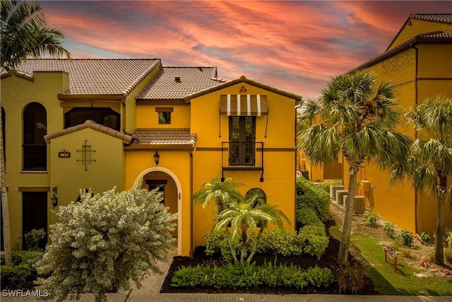 mediterranean / spanish home with a tile roof and stucco siding