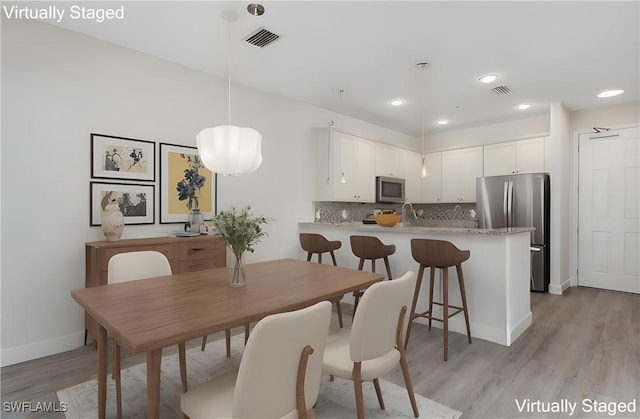 dining space with recessed lighting, visible vents, light wood-style flooring, and baseboards