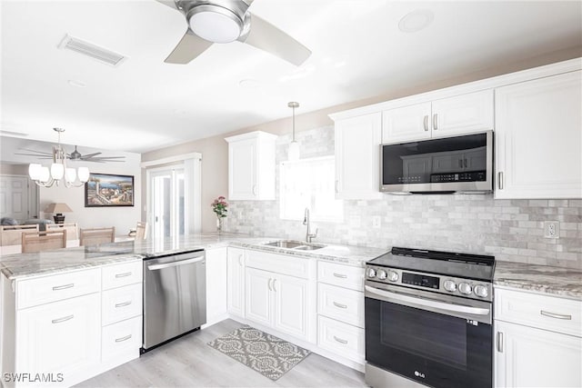 kitchen featuring visible vents, ceiling fan, appliances with stainless steel finishes, a peninsula, and a sink