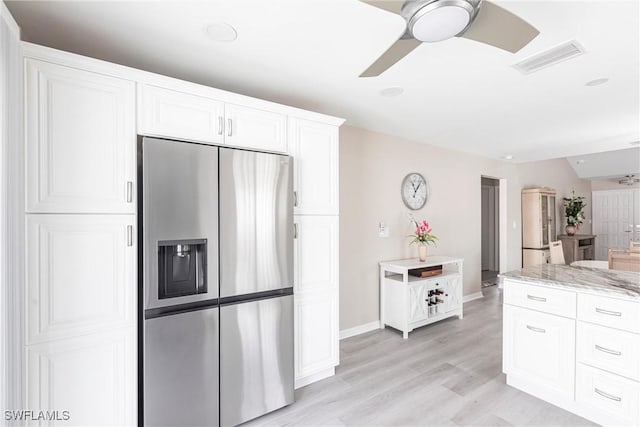 kitchen featuring visible vents, white cabinets, ceiling fan, light stone countertops, and stainless steel fridge with ice dispenser