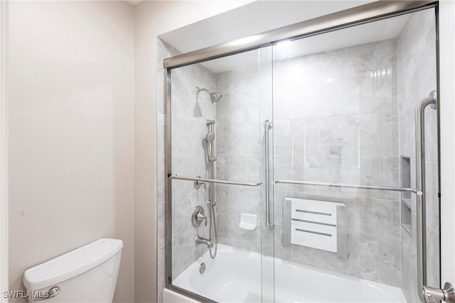 bathroom featuring bath / shower combo with glass door and toilet