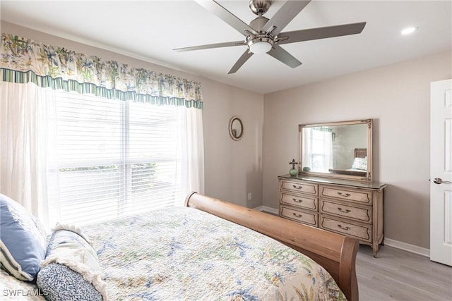 bedroom with a ceiling fan, light wood-type flooring, and baseboards