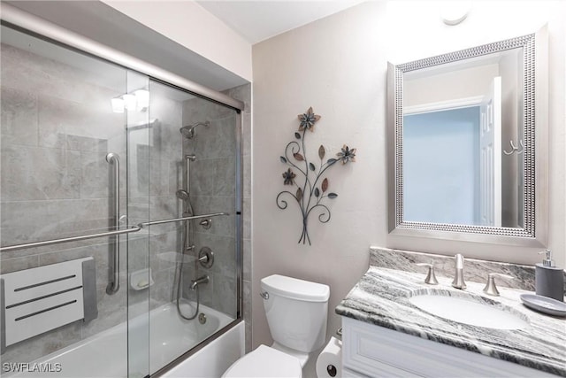 full bathroom featuring toilet, shower / bath combination with glass door, and vanity