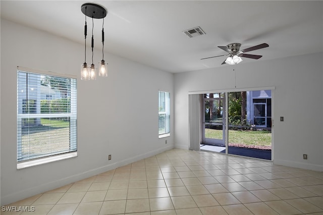 tiled empty room with visible vents, baseboards, and ceiling fan with notable chandelier