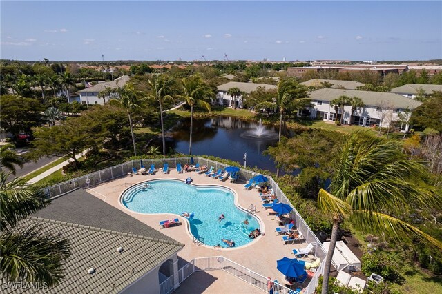 community pool featuring a water view, a patio, and fence