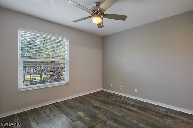 empty room with dark wood-style flooring, a ceiling fan, and baseboards