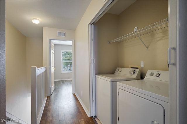 washroom featuring visible vents, dark wood-type flooring, separate washer and dryer, laundry area, and baseboards