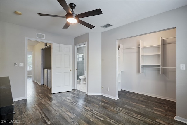 unfurnished bedroom featuring baseboards, visible vents, dark wood-style flooring, and washer and dryer