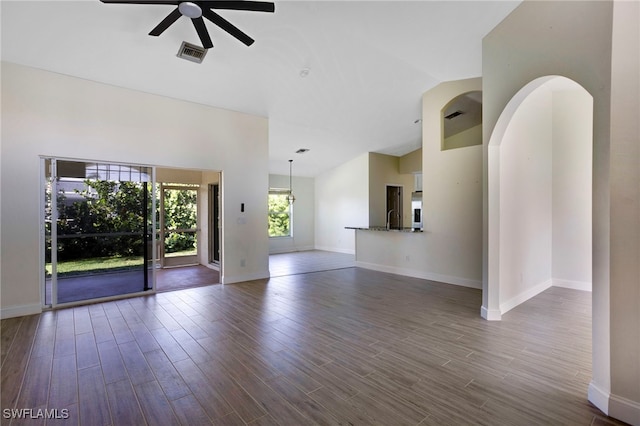 spare room featuring lofted ceiling, a ceiling fan, visible vents, and dark wood-style flooring