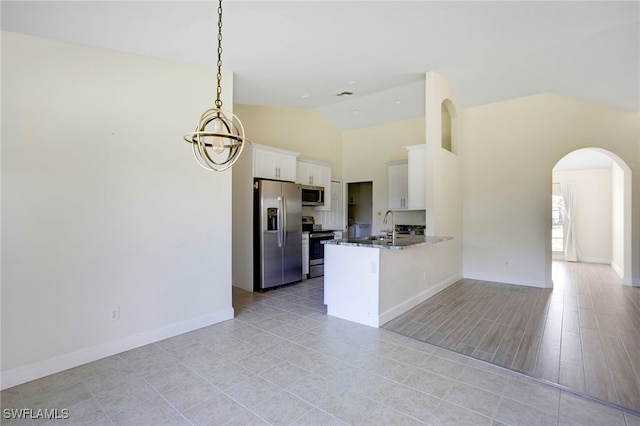 kitchen with open floor plan, stainless steel appliances, arched walkways, a peninsula, and white cabinets