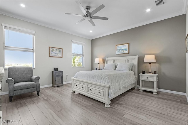 bedroom with visible vents, baseboards, light wood-style floors, and ornamental molding