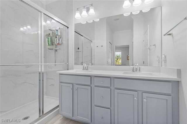 full bathroom with double vanity, a marble finish shower, and a sink