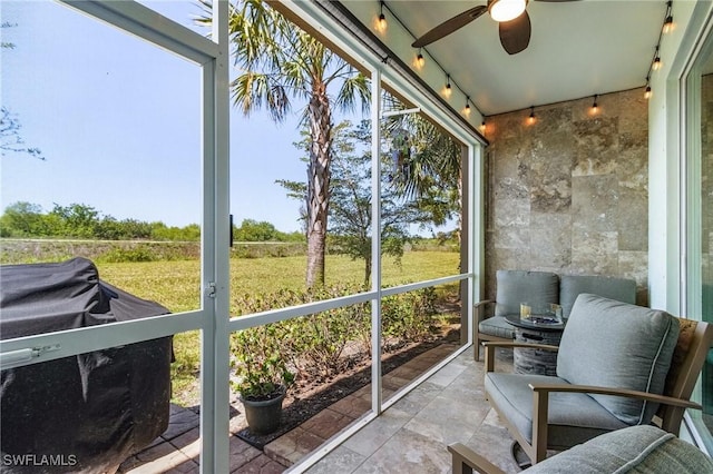 sunroom with rail lighting and a ceiling fan