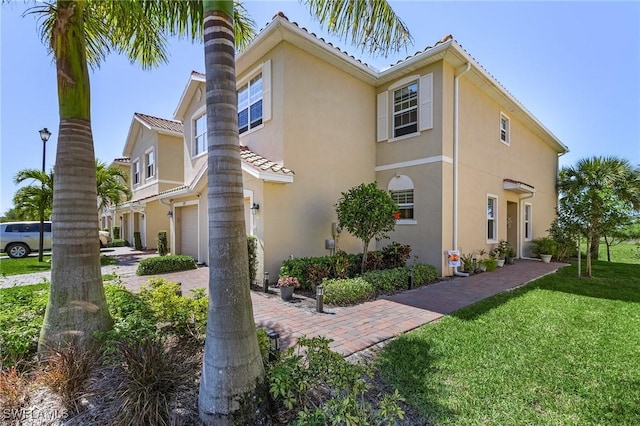 view of side of home with a yard, a garage, and stucco siding