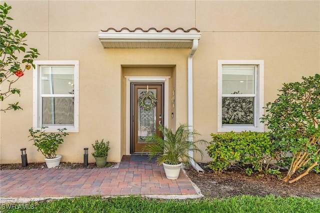 entrance to property featuring stucco siding