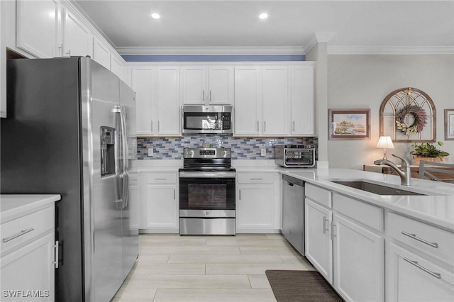 kitchen featuring tasteful backsplash, appliances with stainless steel finishes, ornamental molding, and white cabinetry