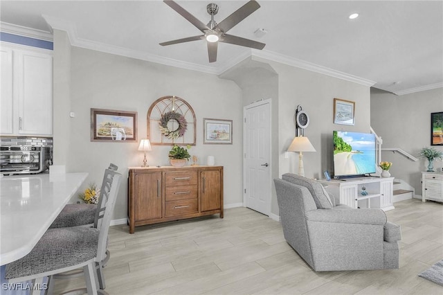 living area featuring crown molding, light wood-style floors, and baseboards